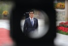 Hong Kong's Chief Executive Leung is seen through a decoration as he walks on the red carpet at Yanqi Lake, Beijing
