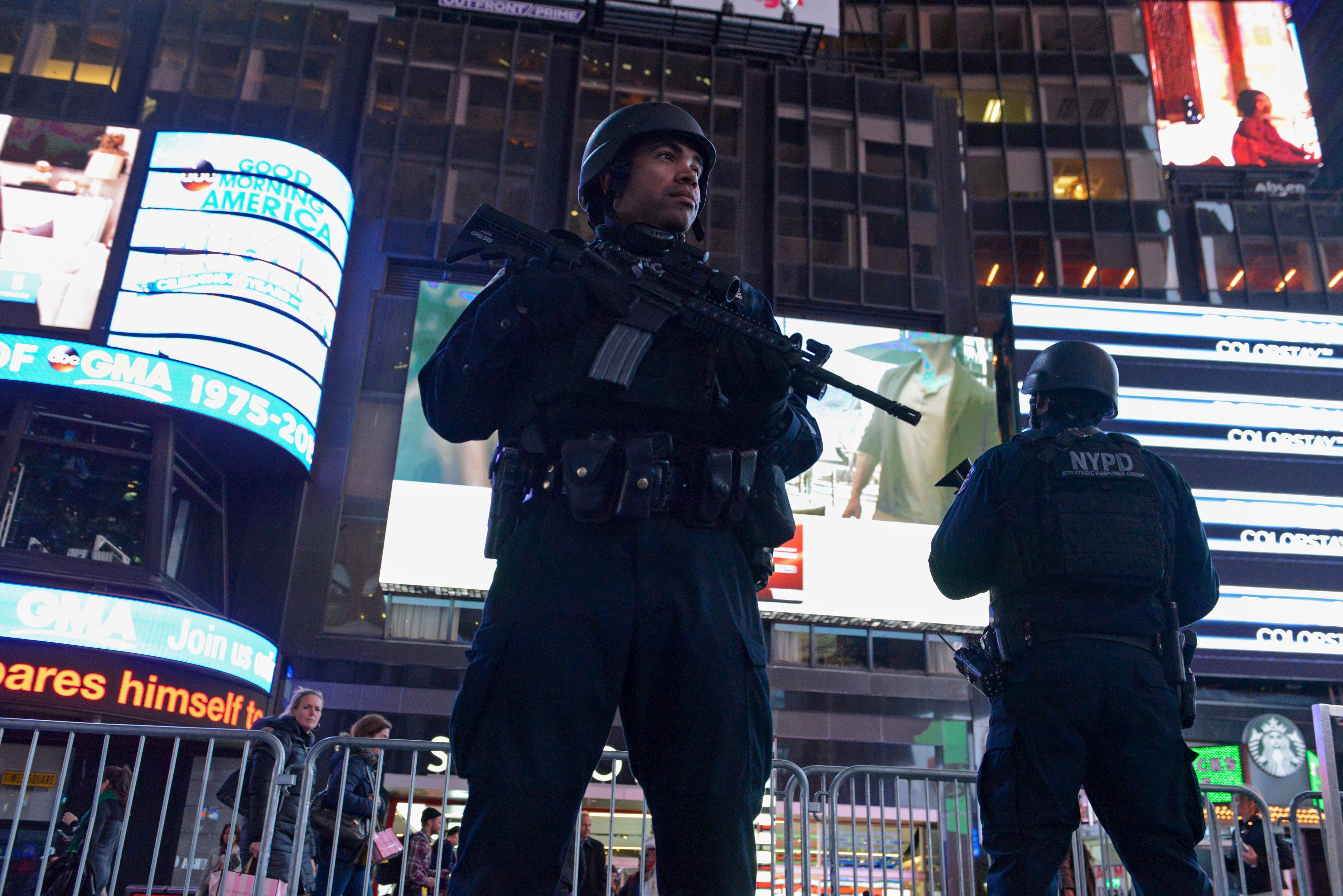 Armed New York City policemen stand guard in Times Square in the Manhattan borough in New York