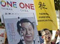 An activist holding a placard showing the merged faces of Taiwan's President Ma and China's President Xi, protests against the upcoming Singapore meeting between Ma and Xi, in front of the Presidentia