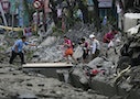 People walk across a gap caused by an explosion in Kaohsiung