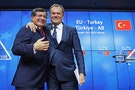Turkish Prime Minister Ahmet Davutoglu and European Council President Donald Tusk greet each other after a news conference following a EU-Turkey summit in Brussels