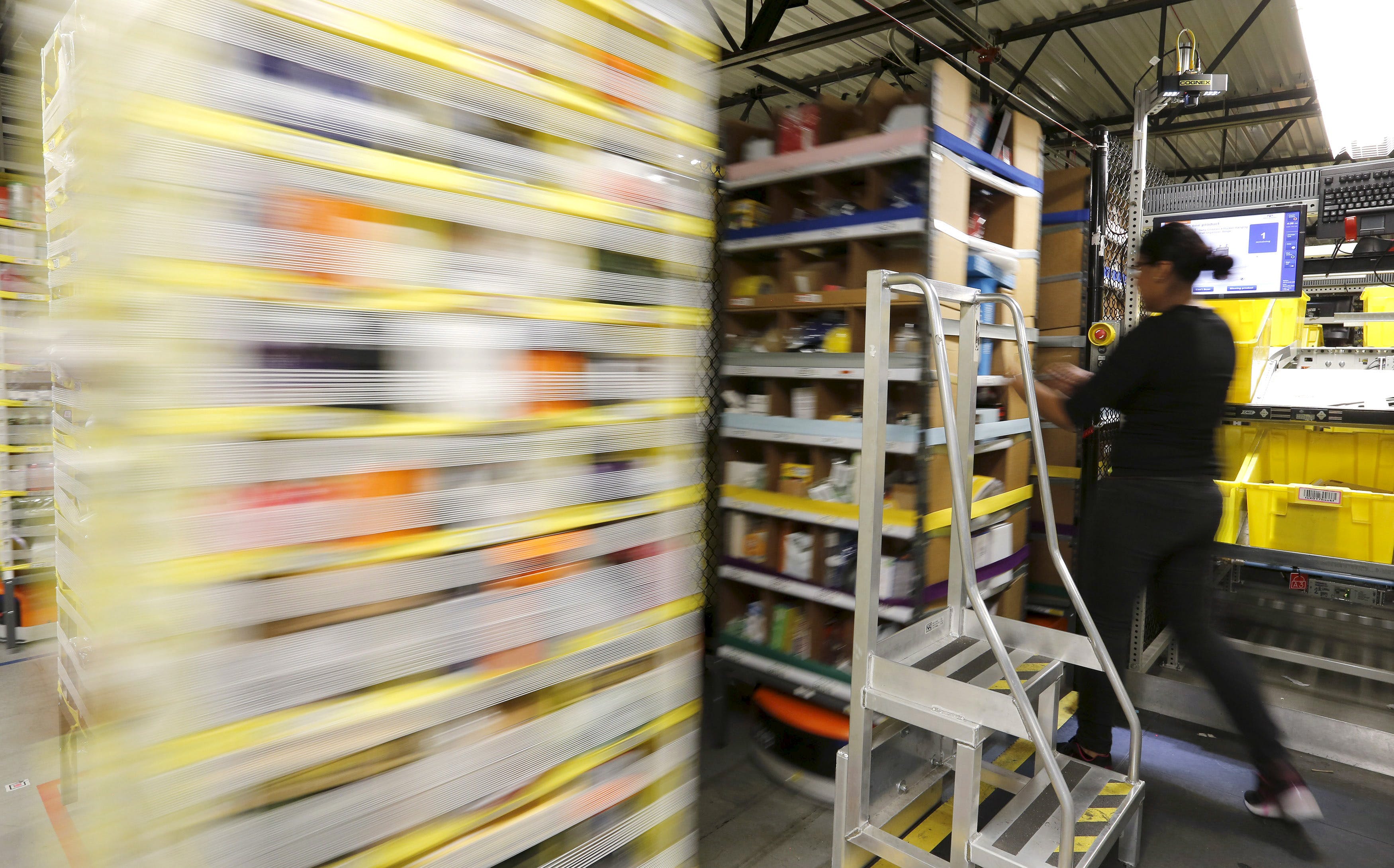 Marvilla pulls items out of robotic bins before they zip away at the Amazon Fulfillment Center in Tracy