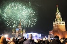 People watch fireworks explode above St Basil's Cathedral next to the Kremlin in Red Square in Moscow