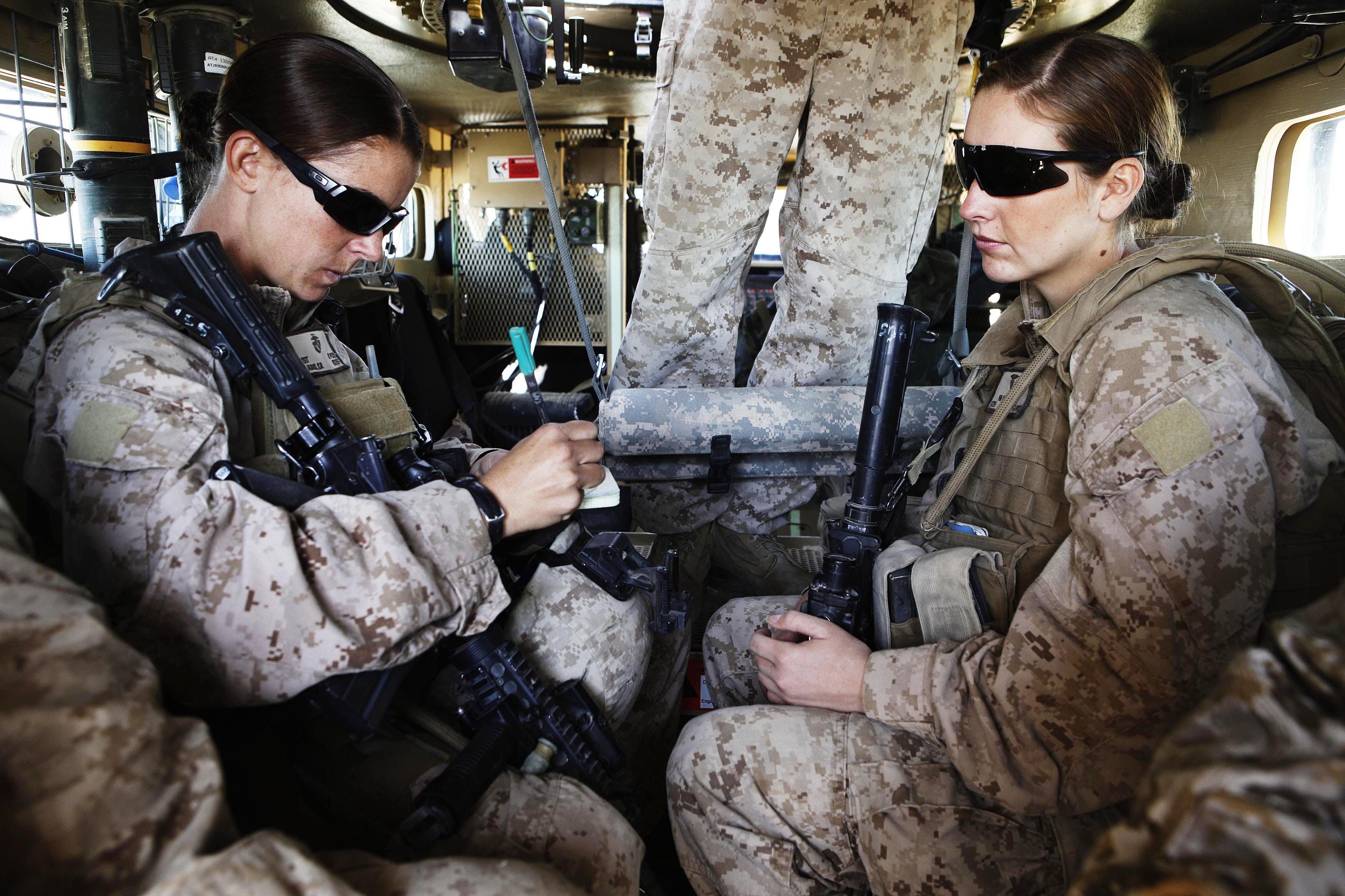 US Marine and Female Engagement Team leader Sgt. Adams and H.N. Crowley sit in armoured vehicle before heading out on an operation in Helmand province