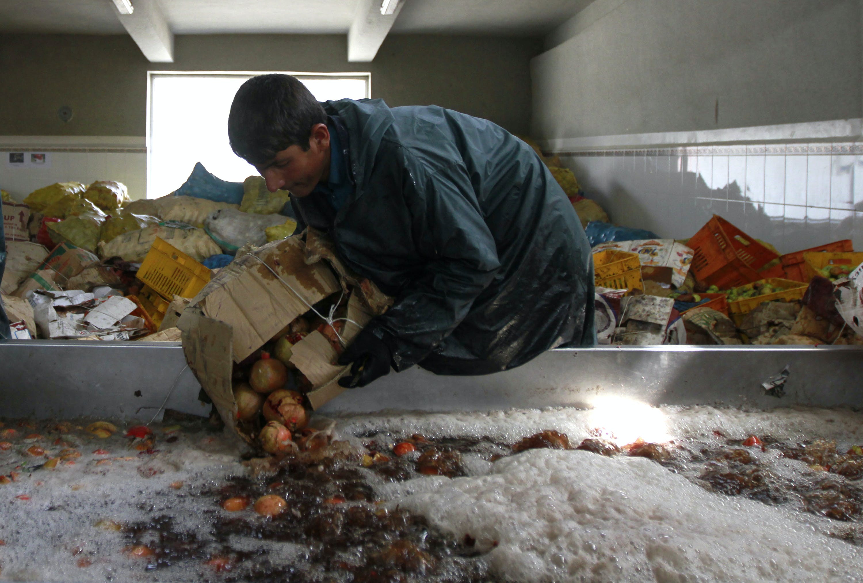 An Afghan man makes pomegranate juice at the Omaid Bahar fruit factory in Kabul
