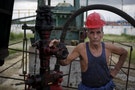 A technician of Cuba's state-run CUPET poses for a picture near an oil pump in Mayabeque province