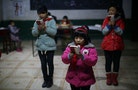 Students read a lecture from Mao Zedong's "Little Red Book" at the Democracy Elementary and Middle School in Sitong town, Henan province