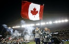 A cheerleader waves a Canadian flag from the back of a pick-up truck during pre-game festivities ahead of the CFL's 103rd Grey Cup championship football game between the Ottawa Redblacks and the Edmon