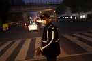 A traffic policeman wears a mask to protect himself from dust and air pollution as he signals to drivers in New Delhi