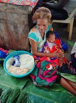 婦女帶著哺乳中的幼兒，摘幾片芭蕉葉鋪地，在市場打地鋪賣菜。Photo Credit：吾燕子