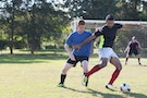 Men playing soccer in playing filed