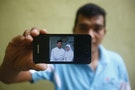 Mohamad shows a wedding picture that he took of Razahan and Norli on his mobile phone during an interview near his house in Kuala Lumpur
