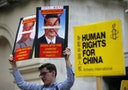 Human rights protesters hold up placards as they wait for China's President Xi Jinping to pass on the Mall during his ceremonial welcome, in London, Britain