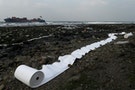 Oil-absorbing materials are seen laid out along a rocky beach after an oil leaked from a cargo ship owned by TS Lines Co, off the shores of New Taipei City