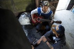 MYITKYINA, BURMA - JANUARY 26: A Pat Jasan member assigned to look after detainees plays guitar on January 26, 2016 in Myitkyina, Burma. Pat Jasan is a Christian anti-drug group in Kachin State claiming over 100,000 members. Dissatisfied with the government's response towards widespread heroin use and poppy growing, the religious organization has taken matters into their own hands, organizing patrols, raiding houses, detaining drug dealers and users, and clearing poppy fields. Their brand of vigilante justice has been labeled extreme with some chapters accused of publicly beating those involved in the drug trade. (Photo by Taylor Weidman/Getty Images)