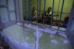 MYITKYINA, BURMA - JANUARY 26: Detainees play music while locked in a room at Pat Jasan headquarters on January 26, 2016 in Myitkyina, Burma. Pat Jasan is a Christian anti-drug group in Kachin State claiming over 100,000 members. Dissatisfied with the government's response towards widespread heroin use and poppy growing, the religious organization has taken matters into their own hands, organizing patrols, raiding houses, detaining drug dealers and users, and clearing poppy fields. Their brand of vigilante justice has been labeled extreme with some chapters accused of publicly beating those involved in the drug trade. (Photo by Taylor Weidman/Getty Images)