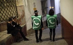 Revellers dressed up as dancers of 'Black Swan' check their mobile phones next to revellers dressed up as a Whatsapp logo as they take part in New Year's celebrations in Coin