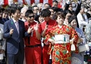 Japan's PM Abe poses with Japanese comedy duos '8.6 second bazooka' and 'Japan erekiteru union' members at a cherry blossom viewing party at Shinjuku Gyoen park in Tokyo