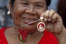 A supporter shows a locket with picture of former Thai Prime Ministers Thaksin Shinawatra and Yingluck Shinawatra, while waiting for former PM Yingluck's arrival at the Supreme Court in Bangkok