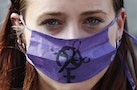 A supporter of a strike by junior doctors wears a surgical mask during a protest outside the Department of Health in London, Britain