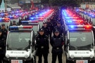 People watch a police force showcase during the debut of new patrolling police vehicles in Chongqing Municipality