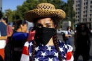 An activist depicting a farmer wears a U.S. flag during a rally against the Trans-Pacific Partnership (TPP) trade deal in front of the government house at Santiago