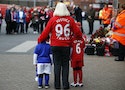 A woman and two children arrive to attend the memorial service for the 96 victims of the Hillsborough disaster at Anfield in Liverpool