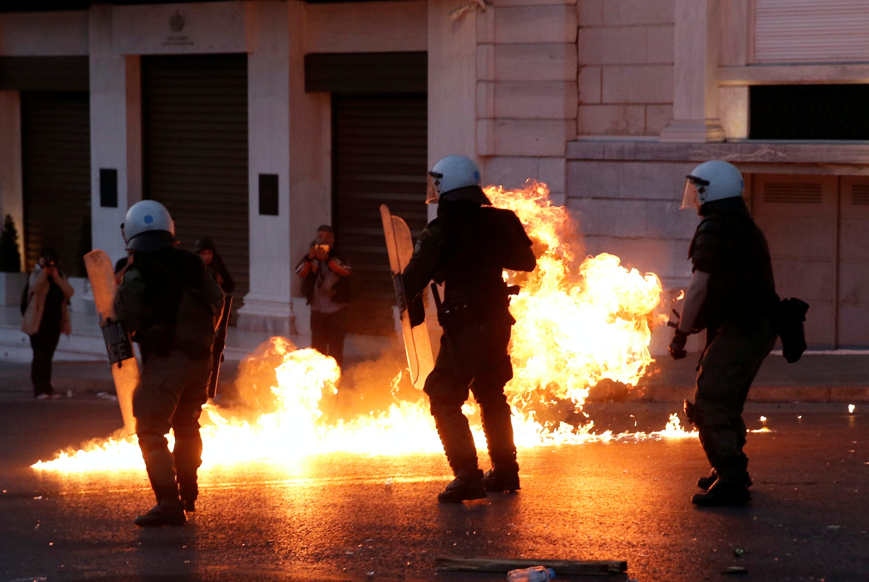 Greek police officers dodge petrol bomb during minor clashes in central Athens