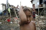 Typhoon victims stand outside their homes damaged by Typhoon Rammasun in Batangas