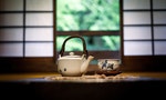 Teapot and tea bowl on a table in a traditional Japanese room in front of Shoji screen windows