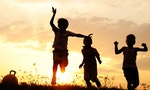 Silhouette, group of happy children playing on meadow, sunset, summertime