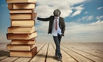 young business man leaning on a stack of books