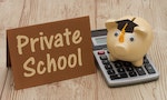 Private School, A golden with grad cap piggy bank, card and calculator on a wood background with text Private School