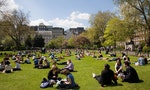Lincoln's Inn Fields in Holborn, London, UK. The lunch time workers enjoy the spring sun on the grass.