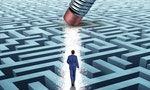 Leadership Solutions with a businessman walking through a complicated maze opened up by a pencil eraser as a business concept of innovative thinking for financial success.