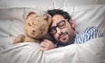SLEEP_Man holding his teddy into bed