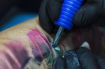 The process of creating a tattoo. Machine for tattoos during work close-up — Photo by njaj