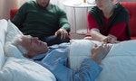 Adult children saying goodbye with aged dying father in hospital