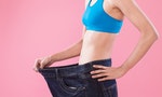 woman wear jeans and show weight loss on the pink background