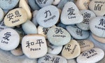 Inspirational words written stones in English and Chinese — Photo by teogeo