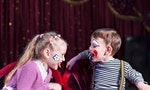 Cute funny boy and girl with painted faces acting as a couple with communication problems, during a theatrical performance