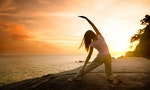 Asian girl posing yoga on beautiful beach during sunset