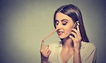 Portrait young woman talking on mobile phone telling lies has a long nose isolated on gray wall background 