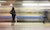 Lone woman watching subway speed by.
