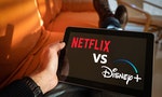 Barcelona, Spain. Jan 2019: Man holds a tablet with Netflix vs Disney+ application logo on screen.Disney + is set to compete with other video streaming subscription services like Netflix,.Illustrative