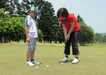 許多家長會在假日帶著小孩一起到球場練習推球，高爾夫運動不限年紀、身形。