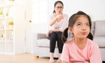 young lovely children was bored with her angry mother loudly nag feeling impatient hate annoying when mom was sitting behind her on sofa in living room at home. - 圖片