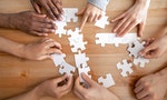 Close up multiracial people, team assembling puzzle, success teamwork and teambuilding concept, students or colleagues finding best creative solution, decision together, hands top view