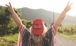 Wenatchee, Washington - July 4, 2019: Republican woman wearing a MAGA hat (Make America Great Again) supporting President Donald Trump and his 2020 re-election campaign, poses with arms raised