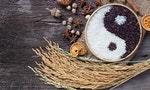陰陽 Yin Yang sign with black rice and jasmine white rice on wooden background. Concept healthy eating,organic food